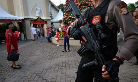 Polisi melakukan penjagaan di halaman gereja katedral jelang misa malam Natal, di Makassar, Sulawesi Selatan.