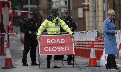 Polisi meletakkan papan yang mengumumkan penutupan jalan terkait insiden teror di Jembatan London dan Pasar Borough, Ahad (4/6).