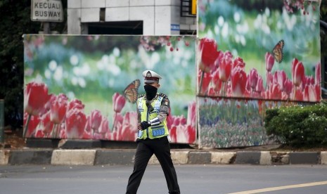 Polisi melewati pos polisi yang Kamis (14/1) menjadi sasaran aksi ledakan Sarinah. Kini pos polisi tersebut ditutup sementara.