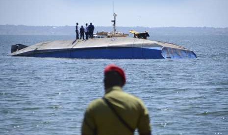  Polisi memandang kapal MV Nyerere yang terbalik di dekat Pulau Ukara, Tanzania, Ahad (23/9). Lebih dari 200 orang meinggal dunia dalam peristiwa kapal karam tersebut.