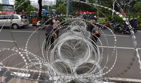 Anggota Direktorat Lalu Lintas Polda Metro Jaya mengalihkan arus lalu lintas kendaraan di sekitar kawasan Istana Merdeka, Jakarta, Kamis (8/10). Ini dilakukan guna mengantisipasi demo buruh menolak Undang-Undang Cipta Kerja.