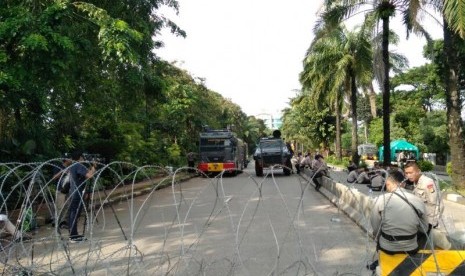 Polisi memasang kawat berduri untuk memisahkan ruas utara dan selatan Jalan Harsono RM, Ragunan, Jakarta Selatan jelang sidang tuntutan terdakwa penistaan agama Basuki Tjahaja Purnama, Selasa (11/4). 