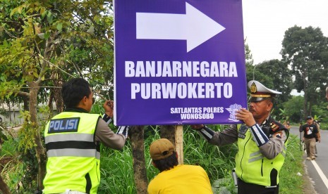 Polisi memasang papan penunjuk arah di pinggir jalan raya Wonosobo-Temanggung-Magelang di jalur mudik poros tengah Kertek, Wonosobo, Jawa Tengah, Selasa (13/6). 