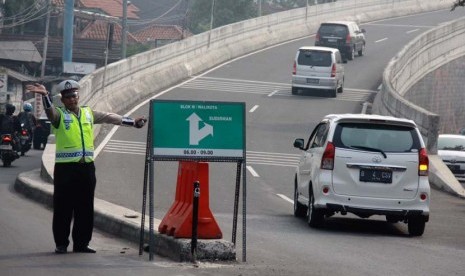 Polisi memasang penutup jalan untuk pemberlakukan satu arah Jalan Layang Non Tol Antasari-Blok M, Jakarta Selatan, Jumat (6/6).