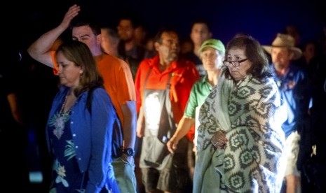 Polisi membantu pengunjung dari Christmas Hill Park menyusul penembakan di festival bawang putih Gilroy Garlic Festival di Gilroy, Kalifornia, Ahad (28/7).