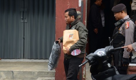 Polisi membawa barang bukti seusai menggeledah rumah kontrakan terduga teroris di Kampung Padasukan, Kecamatan Indihiang, Kota Tasikmalaya, Jawa Barat, Kamis (15/12). 