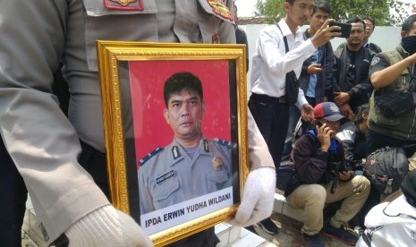 Polisi membawa foto Ipda Erwin Yudha Wildani. Ipda Erwin meninggal dunia usai menderita luka bakar hingga 70 persen, Senin (26/8). Almarhum akan dimakamkan di TMP Cikaret Cianjur.