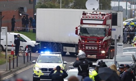 Polisi membawa truk kontainer berisi 39 jenazah dari kawasan industri di Thurrock, selatan Inggris, Rabu (23/10).