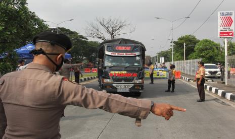 Polisi memberhentikan kendaraan untuk diperiksa saat penyekatan akses masuk Jembatan Suramadu.