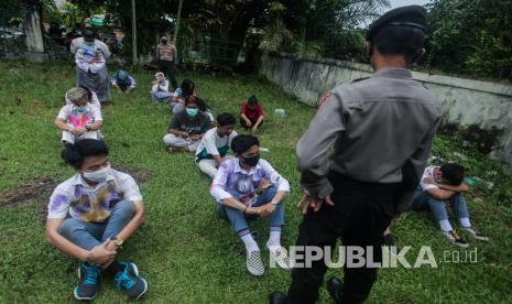 Polisi memberikan arahan ke sejumlah pelajar SMA yang terjaring razia saat melakukan perayaan kelulusan UN di kawasan kota Palangkaraya, Kalimantan Tengah, Ahad (3/5/2020). Personel Polda Kalteng membubarkan perayaan kelulusan tersebut dengan memberikan hukuman push-up dan mengimbau ke pelajar untuk tetap di rumah masing-masing guna mencegah penyebaran COVID-19. A