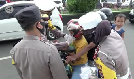 Polisi memberikan masker kepada para pengendara saat Operasi Zebra di Pandeglang, Banten.