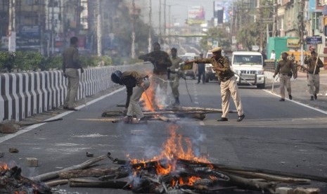 15 Ulama India Ditahan Saat Hendak Demo UU Kewarganegaraan. Polisi membersihkan kayu yang dibakar di tengah jalan oleh pendemo di Gauhati, India, Kamis (12/12). Polisi menahan puluhan orang dan menerapkan jam malam di sejumlah distrik di Assam. India meloloskan RUU Amandemen Kewarganegaraan yang dinilai diskriminatif terhadap Muslim.