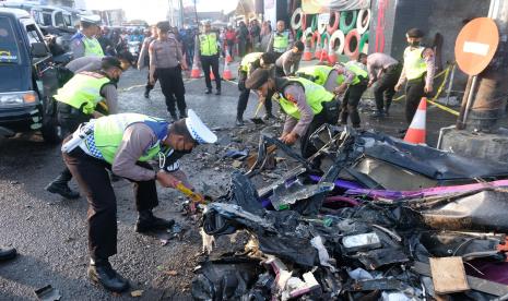 Polisi membersihkan puing-puing mobil pikap yang ringsek di lokasi kecelakaan maut jalan raya Parakan-Wonosobo Kertek, Wonosobo, Jawa Tengah, Sabtu (10/9/2022). Kecelakaan lalu lintas itu diduga akibat rem bus pariwisata bernomor plat N 7944 US tidak berfungsi sehingga menabrak empat mobil lainnya dan mengakibatkan enam orang tewas serta seorang luka berat.