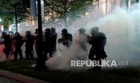 Polisi membersihkan taman selama bentrokan dengan pengunjuk rasa di luar Gedung Pengadilan Kabupaten Kenosha pada Selasa malam, 25 Agustus 2020, di Kenosha, Wis., Selama demonstrasi atas penembakan pada hari Minggu terhadap Jacob Blake. 