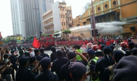 Polisi membubarkan massa pendukung PM Malaysia Najib Razak dengan semprotan air, Rabu (16/9).