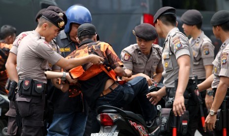 Polisi memeriksa barang bawaan seorang anggota organisasi kepemudaan (OKP) di Medan.