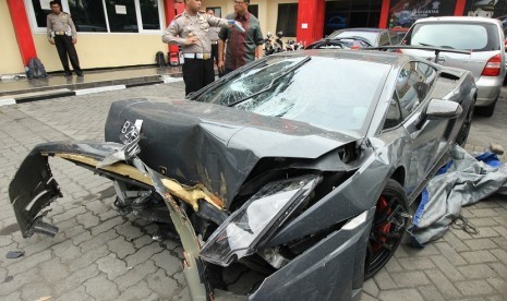 Polisi memeriksa barang bukti mobil Lamborghini yang rusak di Unit Kecelakaan Satuan Lalu Lintas Polrestabes Surabaya, Jawa Timur, Minggu (29/11)