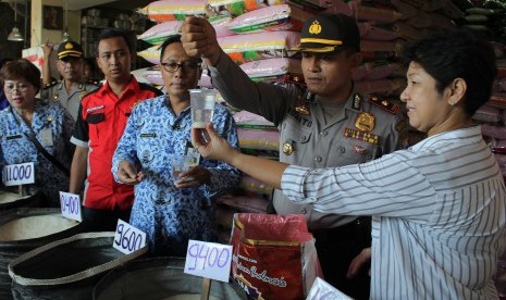 Polisi memeriksa butiran beras di Surabaya, Jawa Timur, Rabu (20/5).