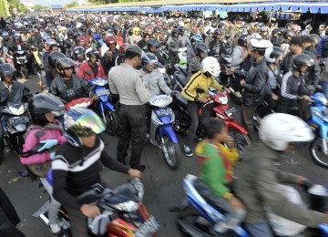 Polisi memeriksa kelengkapan surat pemudik bersepeda motor saat antre di Pelabuhan Gilimanuk, Bali, Ahad (28/8). 