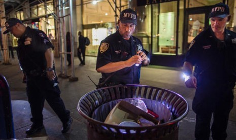 Polisi memeriksa paket mencurigakan di sepanjang Fifth Avenue dekat lokasi ledakan di West 23rd Street dan 6th Avenue di Chelsea, Manhattan, New York, Ahad dini hari waktu setempat.