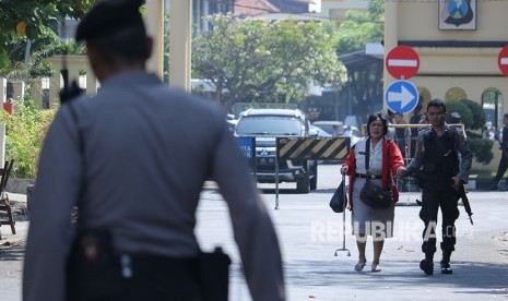 Polisi memgevakuasi Pegawai Negeri Sipil dari Polrestabes Surabaya setelah terjadi ledakan, Surabaya, Jawa Timur, Senin (14/5).