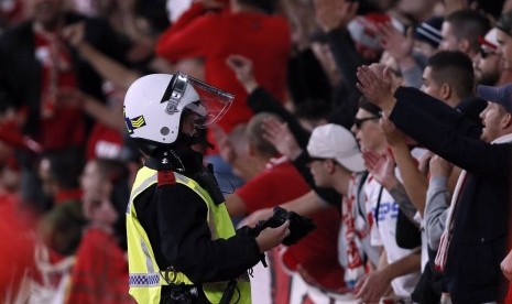 Polisi memperhatikan tindak tanduk pendukung Cologne saat mendukung timnya di Stadion Emirates melawan Arsenal, Jumat (15/9) dini hari WIB.