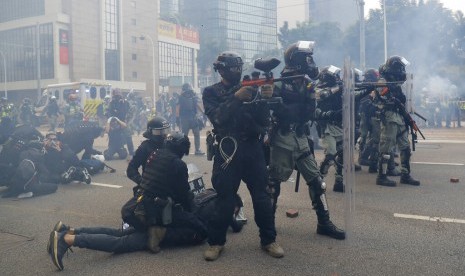 Polisi menahan pengunjuk rasa dalam demonstrasi di Hong Kong, Ahad (29/9). Polisi antihuru-hara menembakkan gas air mata ke demonstran di Hong Kong jelang Hari Kemerdekaan China.