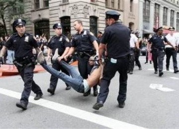 Polisi menahan satu demonstran dalam unjuk rasa anti ketamakan di Wall Street, New York, Sabtu (25/9/2011)