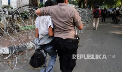 Polisi menangkap satu orang pemuda berseragam Sekolah Menengah Atas (SMA) di depan gedung Dewan Perwakilan Rakyat (DPR) RI. Ilustrasi.