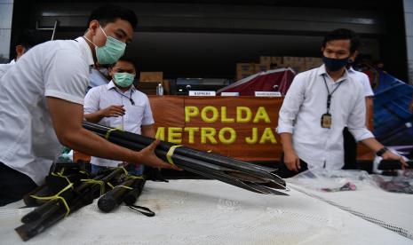 Polisi menata barang bukti saat rilis kasus kejahatan kelompok John Kei di Polda Metro Jaya, Jakarta, Senin (22/6/2020). Tim gabungan Polda Metro Jaya berhasil menangkap 30 orang yakni John Kei beserta anggota kelompoknya dalam kasus pengeroyokan, pembunuhan dan kekerasan di kawasan Duri Kosambi, Jakarta Barat dan Perumahan Green Lake City, Kota Tangerang, Banten pada Minggu 21 Juni 2020.