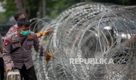 Polisi menata barikade kawat berduri (ilustrasi).