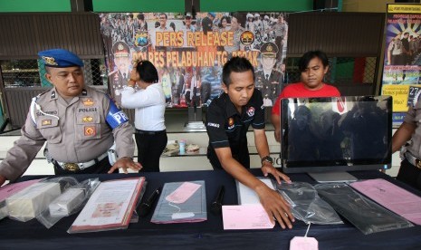 Polisi menata sejumlah barang bukti saat gelar kasus pungutan liar di Polres Pelabuhan Tanjung Perak Surabaya, Jawa Timur, Rabu (2/11).