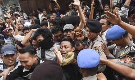 Polisi mendorong warga yang melakukan pengadangan kepada calon Wakil Gubernur DKI Jakarta Djarot Saiful Hidayat saat melakukan blusukan di kawasan Karanganyar, Jakarta, Senin (14/11).