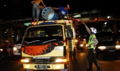 Polisi menertibkan mobil peserta takbir keliling tahun lalu. 