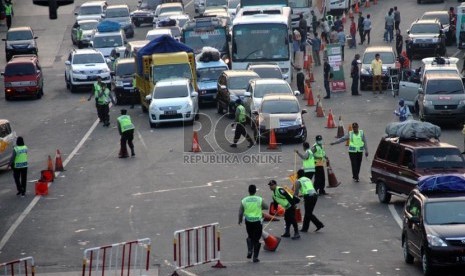  Polisi mengalihkan arus kendaraan ke arah Sadang, Purwakarta saat keluar Gerbang Tol Cikampek, Jawa Barat, Ahad (4/8).   (Republika/ Yasin Habibi)