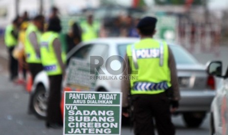  Polisi mengalihkan arus kendaraan ke arah Sadang, Purwakarta saat keluar Gerbang Tol Cikampek, Jawa Barat, Ahad (4/8).   (Republika/ Yasin Habibi)