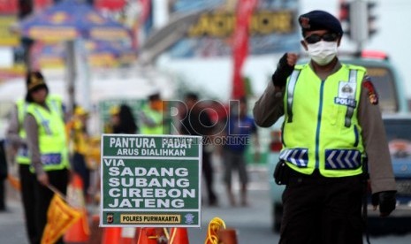  Polisi mengalihkan arus kendaraan ke arah Sadang, Purwakarta saat keluar Gerbang Tol Cikampek, Jawa Barat, Ahad (4/8).   (Republika/ Yasin Habibi)