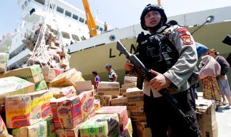 Polisi mengamankan aktivitas bongkar muat bantuan makanan untuk korban gempa dan tsunami Palu serta Donggala di Pelabuhan Kelas-III Pantoloan, Palu, Sulawesi Tengah, Senin (1/10). 