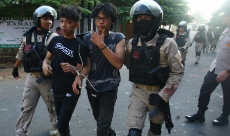 Polisi mengamankan dua orang yang diduga sebagai provokator saat terjadinya kerusuhan di atas jalan layang Slipi Jaya, Jakarta, Rabu (22/5/2019).