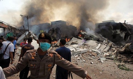  Polisi mengamankan lokasi jatuhnya pesawat Hercules C-130 TNI AU di Medan, Selasa (30/6). (EPA/Dedi Sahputra)