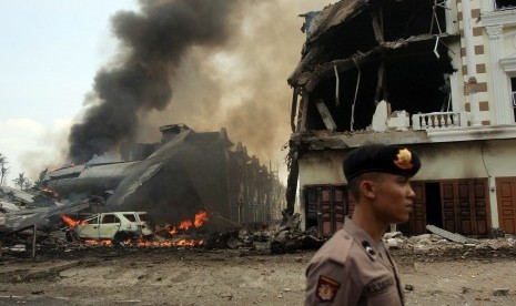  Polisi mengamankan lokasi jatuhnya pesawat Hercules C-130 TNI AU di Medan, Selasa (30/6). (EPA/Dedi Sahputra)