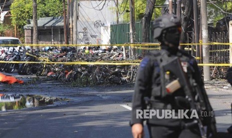 Polisi mengamankan lokasi parkir sepeda motor tempat ledakan bom terjadi di Gereja Pantekosta, Surabaya, Ahad (13/5) 