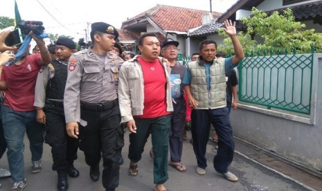 Polisi mengamankan Nahwan Hadi (kaos merah) warga yang menolak kedatangan Calon Gubernur DKI Jakarta nomor urut dua, Basuki Tjahja Purnama atau Ahok saat blusukan ke Jalan Turi, Lenteng Agung, Jagakarsa, Jakarta Selatan, Jumat (6/1) pagi.