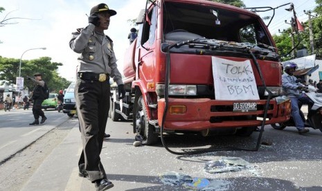  Polisi mengamankan sebuah mobil tangki yang dirusak sejumlah mahasiswa saat berunjuk rasa menentang kenaikan BBM di depan kampus Universitas Muhammadiyah (Unismuh) di Makassar, Sulsel, Rabu (24/4).  (Antara/Yusran Uccang)