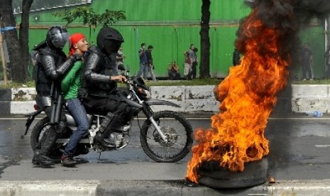 Polisi mengamankansalah seorang pengunjukrasa yang diduga provokator saat terjadi bentrokan di depan kantor KPU Sulsel, Makassar, Jumat (7/3). Aksi tersebut merupakan simulasi pengamanan Pemilu 2014 untuk menjaga keamanan pesta demokrasi lima tahunan terse