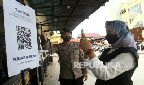 Polisi mengarahkan pengunjung untuk memindai kode batang (QR Code) melalui aplikasi PeduliLindungi sebelum memasuki Polresta Pontianak di Pontianak, Kalimantan Barat, Selasa (19/10/2021). Polresta Pontianak menerapkan penggunaan aplikasi PeduliLindungi kepada anggota polisi maupun pengunjung sebagai upaya mendukung program pemerintah untuk mencegah penyebaran COVID-19.