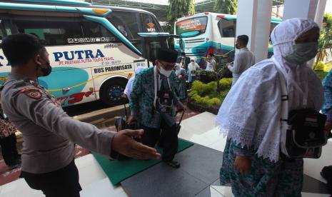 Polisi mengarahkan sejumlah jamaah calon haji memasuki Asrama Haji Surabaya, Jawa Timur, Kamis (16/6/2022). Terhitung sejak pemberangkatan kloter pertama ke Tanah Suci pada Sabtu (4/6/2022) sebanyak 8.063 jamaah calon haji telah diberangkatkan dari Asrama Haji Surabaya ke Tanah Suci untuk menunaikan ibadah haji. 