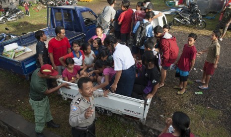 Polisi mengatur anak-anak pengungsi Gunung Agung yang berangkat ke sekolah sementara untuk mengisi waktu mereka selama di penampungan di Desa Manggis, Karangasem, Bali, Selasa (26/9). 