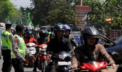 Polisi mengatur lalu lintas pemudik motor untuk menggunakan jalur kiri di kawasan jalur selatan Nagreg, Jawa Barat.