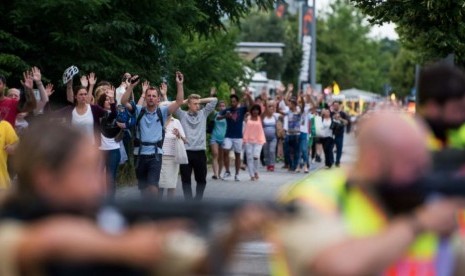 Polisi mengawal evakuasi orang-orang dari pusat perbelanjaan Olympia Einkaufzentrum (OEZ) di Munich, Jerman (22/7), menyusul penembakan di sana. 